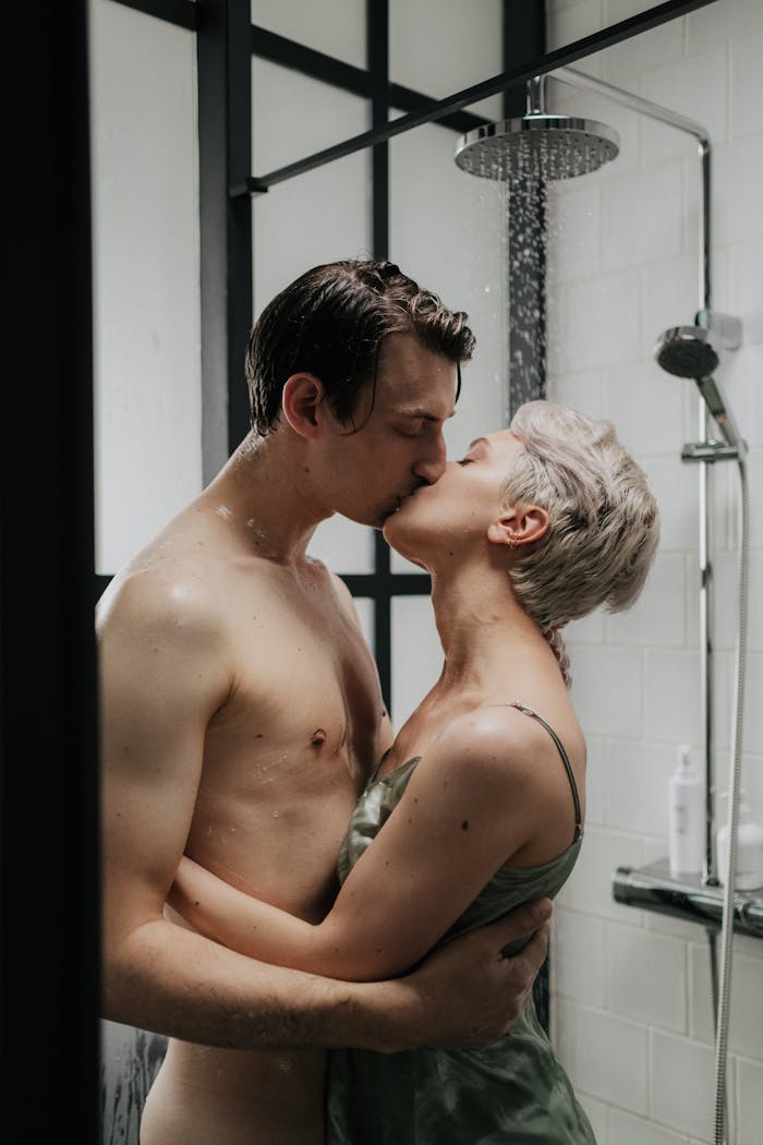 who-we-are-02 A romantic moment captured between a couple kissing passionately under a shower.